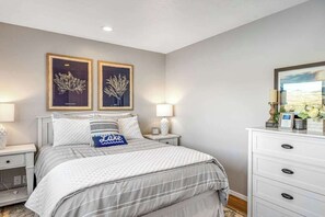 A bedroom with a bed, bedside tables, a dresser, and wall art. - Large 2BR Lakefront - Hot Tub - Dock - Patio (Chelan)