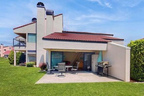 A modern two-story house with a patio, outdoor furniture, and a barbecue grill. - Studio Lakefront 1st-floor - Patio - Pool (Chelan)