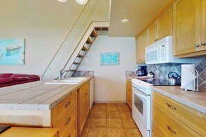 A kitchen with wooden cabinets, a microwave, and a kettle on the counter. - Studio Lakefront 1st-floor - Patio - Pool (Chelan)