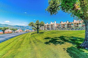 Un hotel con edificios de varios pisos, un césped cuidado y una vista despejada del paisaje circundante.