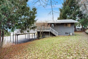 A house with a deck, a staircase, and a view of a body of water.