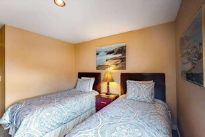 Ein Hotelzimmer mit zwei Betten, einem Nachttisch mit Lampe und einem Bild an der Wand.