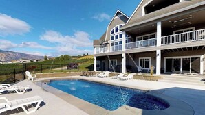 Ett hus i två våningar med en swimmingpool, en uteplats och utsikt över bergen.