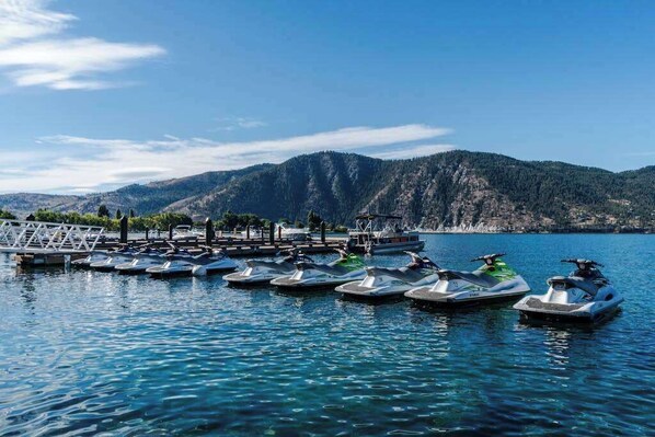 A marina with several small boats docked, a wooden pier, and a mountainous backdrop. - Luxury home - wine country - private pool, hot tub (Manson)