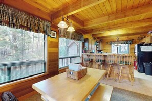 A wooden interior with a dining area, kitchen, and large windows. - Cozy 2BR Mountainview Dog Friendly Getaway (Leavenworth)