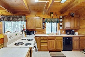 A wooden cabin kitchen with a stove, microwave, and dishwasher. - Cozy 2BR Mountainview Dog Friendly Getaway (Leavenworth)