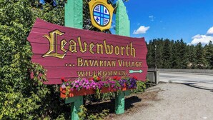 En träskylt med texten ”Leavenworth Bavarian Village” och ”Willkommen” som visar att det är ett område där besökare är välkomna.