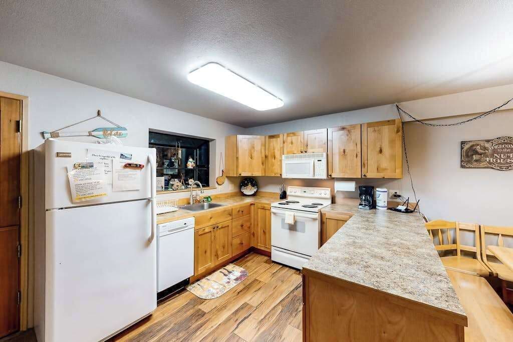A kitchen with wooden cabinets, a white refrigerator, a stove, and a microwave.