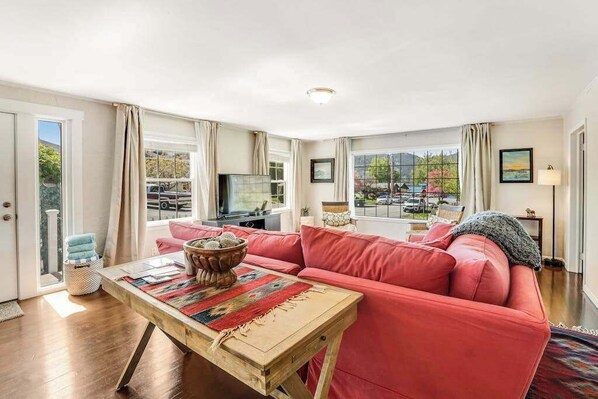 A living room with a red sofa, a wooden coffee table, and a television.