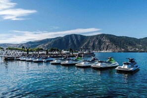 A marina with several small boats docked, a wooden pier, and a mountainous backdrop. - 3BR Lakeview Dog Friendly - Patio - W&D (Manson)