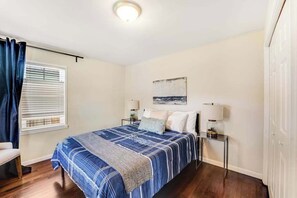 A bedroom with a bed, bedside tables, a window with curtains, a painting on the wall, and a ceiling light. - 3BR Lakeview Dog Friendly - Patio - W&D (Manson)