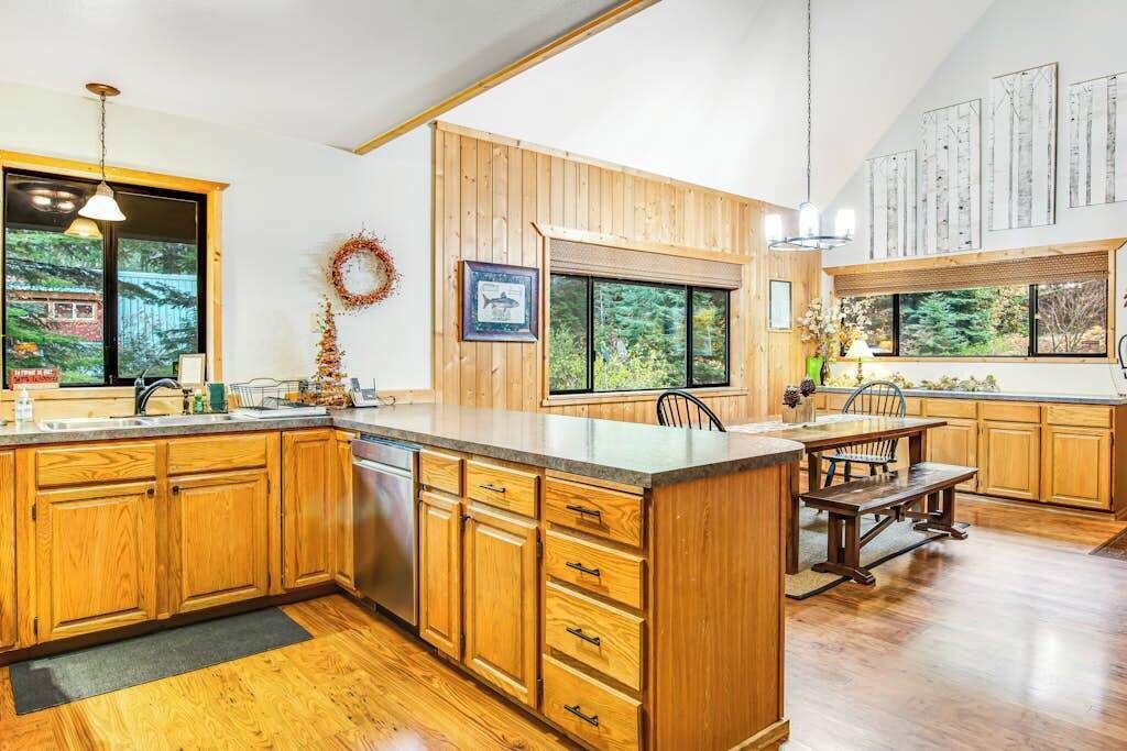 A spacious kitchen with wooden cabinets, a large island, and a dining area.