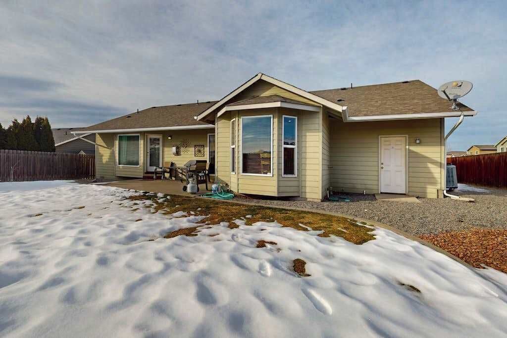 A single-story house with a covered patio, a satellite dish, and a front door.