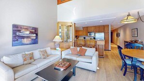 Ein modernes Wohnzimmer mit Sofa, Couchtisch und einem Bild an der Wand.