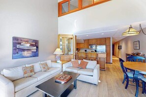 Ein modernes Wohnzimmer mit Sofa, Couchtisch und einem Bild an der Wand.
