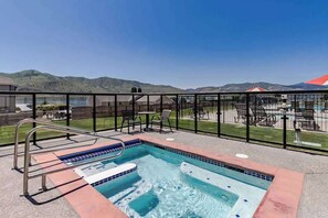 A rooftop pool with a view of hills and a fenced patio area. - 1BR Lakeview 2nd-Floor - Balcony - Pool (Chelan)