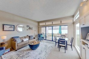 A living room with a sofa, coffee table, and a dining area with chairs and a table. - 1BR Lakefront - Pool - Hot Tub - Game Room (Chelan)