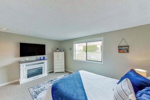 A hotel room with a bed, a television, a dresser, and a window with a view. - 1BR Lakefront - Pool - Hot Tub - Game Room (Chelan)