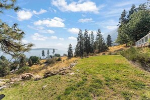 A grassy area with a view of a lake and mountains in the distance. - Large 2BR Lakeview - Hot Tub - Deck - Game Room (Chelan)