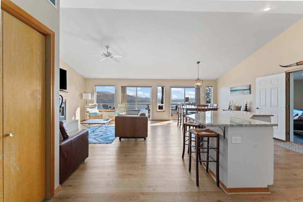 Een ruime woonkamer met een bank, een eettafel en een keukeneiland.