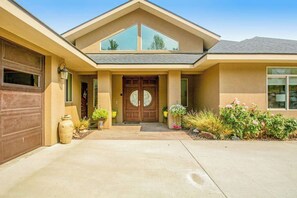A two-story house with a front entrance, garage, and a landscaped garden. - 4BR Mountainview Dog Friendly - Chef's Kitchen (Orondo)