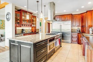 A modern kitchen with granite countertops, stainless steel appliances, and wooden cabinets.