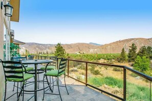 A balcony with a table and chairs, overlooking a mountainous landscape. - 4BR Mountainview Dog Friendly - Chef's Kitchen (Orondo)