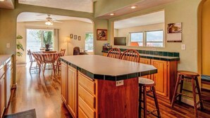 Una cocina con armarios de madera, una isla grande y taburetes de bar.