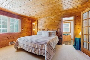 A wooden-paneled bedroom with a bed, a nightstand, and a window. - Spacious 3BR Mountainview - Fireplace - Deck (Leavenworth)
