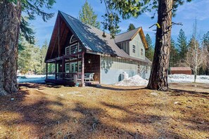 A cabin with a large porch, a covered outdoor seating area, and a snow-covered ground. - Spacious 3BR Mountainview - Fireplace - Deck (Leavenworth)