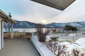 Ein Balkon mit Blick auf verschneite Berge und ein Gewässer.
