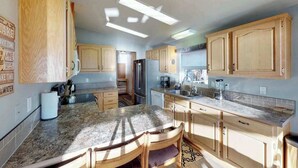 Eine Küche mit Holzschränken, einer Granit Arbeitsplatte und einem eingebauten Backofen.