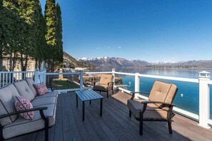 A deck with outdoor furniture overlooking a lake and mountains. - Lakefront 3BR with private dock & amazing views (Chelan)