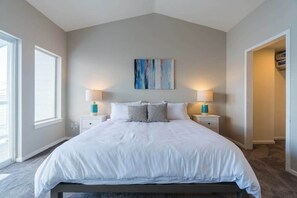 A bedroom with a large bed, two bedside tables, a wall-mounted artwork, and a window. - Lakefront 3BR with private dock & amazing views (Chelan)