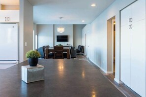 A modern kitchen with a built-in refrigerator, a dining area with a table and chairs, and a flat-screen TV mounted on the wall. - Lakefront 3BR with private dock & amazing views (Chelan)