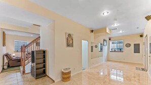 A spacious living area with a staircase, a fireplace, and a large window. - Spanish-style 6BR Mountainview - Deck - W&D (East Wenatchee)