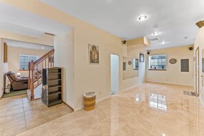 A spacious living area with a staircase, a fireplace, and a large window. - Spanish-style 6BR Mountainview - Deck - W&D (East Wenatchee)