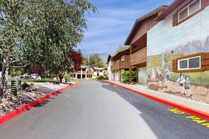 A street with a red curb, buildings with balconies, and a mural on the wall. - Downtown Studio 1st-Floor - Icicle Village Resort (Leavenworth)