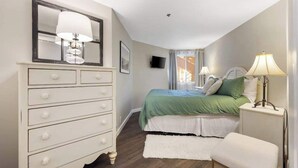 Una camera da letto con un letto, una cassettiera e lampade da comodino.