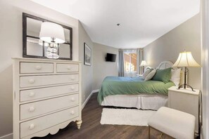 Ein Schlafzimmer mit Bett, Kommode und Nachttischlampen.