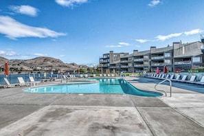 A swimming pool with lounge chairs and a view of a mountainous landscape.