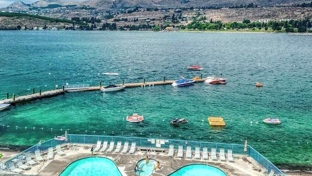 Una piscina con vista su un lago e barche.