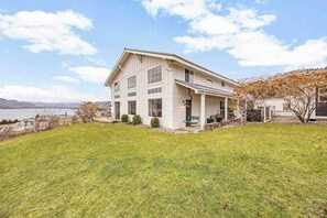 A two-story house with a covered porch and a view of a lake. - 2BR home with great views & located on winery (Chelan)