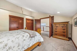 Un dormitorio con cama, armario de madera y vistas a un balcón.