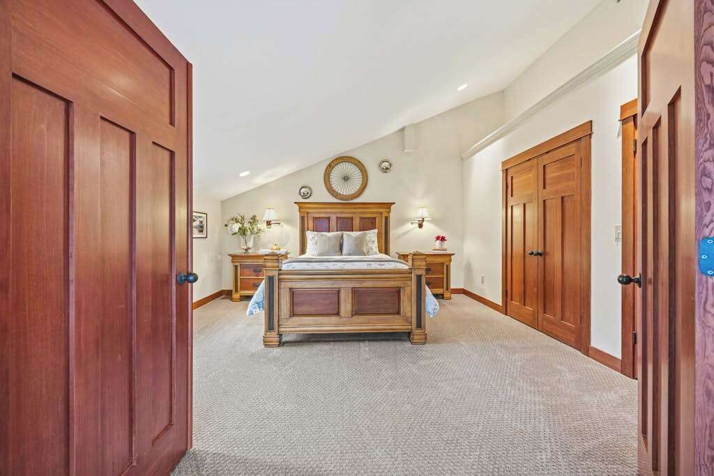 Ein Schlafzimmer mit einem großen Bett, einem Holzschrank und Teppichboden.