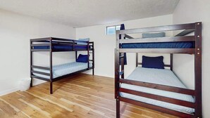 A room with two bunk beds, wooden flooring, and white walls. - 3BR Home & Bunk Room with hot tub, mountain views (East Wenatchee)