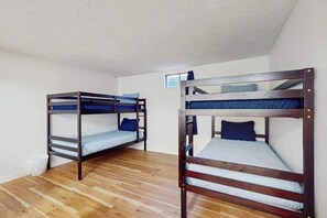 A room with two bunk beds, wooden flooring, and white walls. - 3BR Home & Bunk Room with hot tub, mountain views (East Wenatchee)