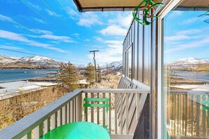 A balcony with a view of a lake and mountains, a metal railing, and a green object on the floor. - Updated 3BR Lakeview - Balcony - Washer/Dryer (Chelan)