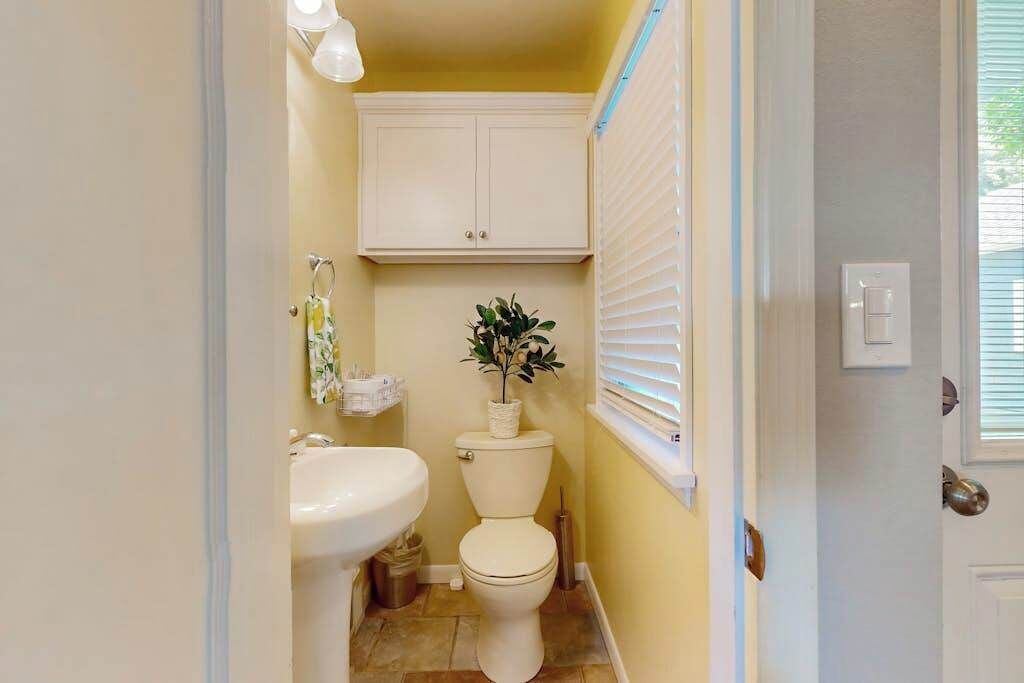 A compact bathroom with a toilet, sink, and cabinet.