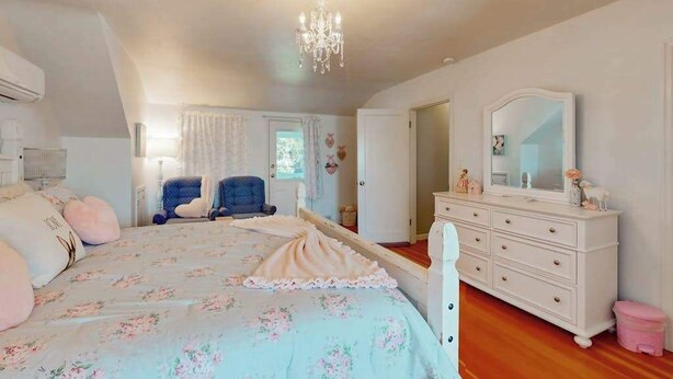 Ein Schlafzimmer mit Bett, Schminktisch und einer Kronleuchter.